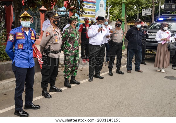 Several people in uniform\
collaborated in socializing the handling and prevention of the\
COVID-19 pandemic in Indonesia. Tegal, Central Java, Indonesia\
17June 2021