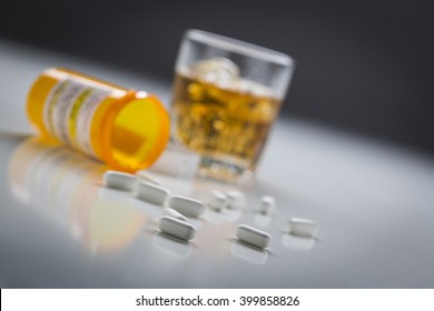 Several Prescription Drugs Spilled From Fallen Bottle Near Glass of Alcohol. - Shutterstock ID 399858826