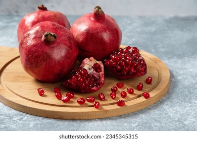 	
					Several ripe pomegranate fruits and an open pomegranate, pomegranate on table, top view, dark background, Fresh ripe pomegranate on black background, selective focus, Healthy pomegranates fruit garn
