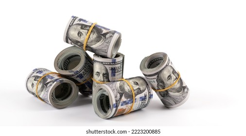 Several rolled-up bundles of 100 American dollars bills on white  background - Shutterstock ID 2223200885
