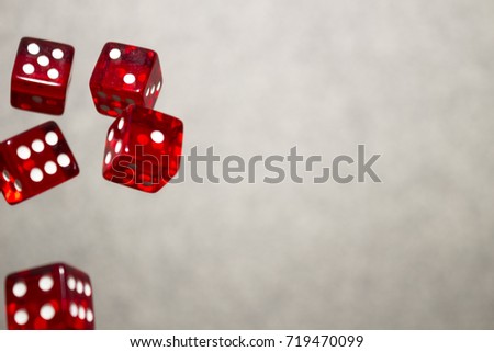 Several rolling red dice fall on a table with boardgame. Gameplay moments.