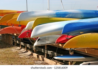 Several rows of pretty, brightly colored canoes
