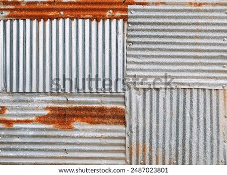 Several sheets of rusty, wavy galvanized metal were stacked together and fastened with nuts.