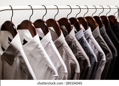 Several shirts on a hanger	 from white to black color range
