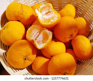 Several Small Orange Friut In The Basket.