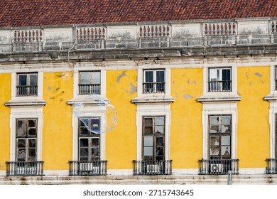Several small soap bubbles float across a bright winter sky above historic yellow buildings in a Lisbon square