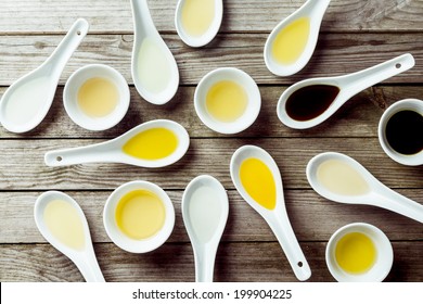 Several soup spoons and sauce dishes arranged randomly on wooden surface - Powered by Shutterstock