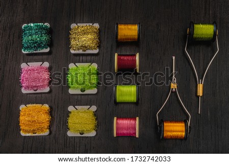 several spools of thread of various types and colours for tying flies. hobby concept