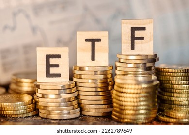 Several stacks with coins and the term ETF and a chart with stock prices.