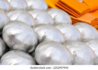 Several stainless steel alms bowls arranged upside down in a temple ordination ceremony in India - Shutterstock ID 2252997993