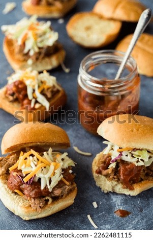 Several toasted pulled pork sliders with homemade barbecue sauce.