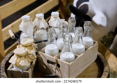 Several Transparent Glass Bottles With Fresh Milk In Wooden Crate At Ecological Farm.