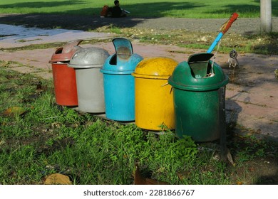 several trash cans that are placed in a row in red, gray, Tosca, yellow and green with the intention that visitors can dispose of garbage in its place according to the category of garbage - Shutterstock ID 2281866767