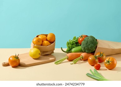 Several types of vegetable and fruit scattered lay on yellow kitchen counter top, against the blue background. Photo of front angle with copy space for adding text - Powered by Shutterstock