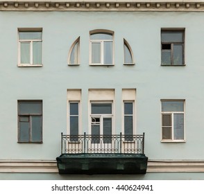 Several windows in a row and balcony on facade of urban apartment building front view, St. Petersburg, Russia