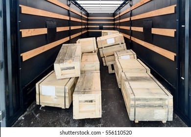 Several Wooden Crates Inside The Cargo Van. The Boxes Piled In A Disorderly Pile. Interior View Of Empty Semi Truck Lorry