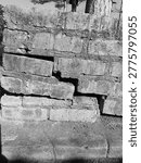Severe structural failure in a red brick wall due to foundation settling, Aged red brick wall with significant cracks and
