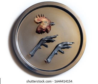 Severed Dead Animal Parts: Butchered Raw Chicken Head And Legs On Silver Tray Like An Ikon Or Logo Symbolizes Meat Eating ; Color Close Up Photo.