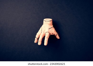 Severed hand Thing from Addams Family on dark background. Halloween holiday decoration.