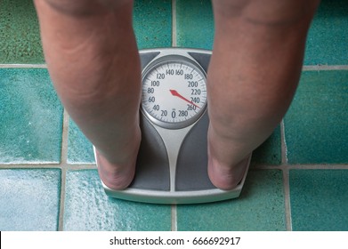 A Severely Overweight Person Weighing Herself Or Himself On A Bathroom Scale