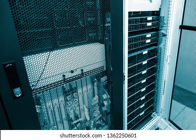 Severs computer in rack at big data center under grid door with green toning. Datacentre interface and equipment. Network and technology futuristic concept