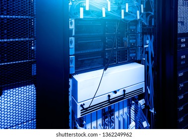 Severs computer in rack at the large data center under blue neon light. Network and technology futuristic concept