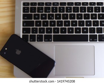 Sevilla, Spain; 06/08/2019: Iphone 8 over MacBook Pro in wood work desktop