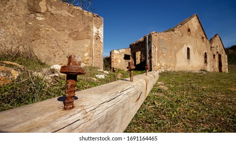 Sevilla / Spain - March 10 2020: Roof Beam Lies On The Ground In Front Of An Old Mining Town Accommodation Block In Cerro Del Hierro National Park In Sevilla Spain