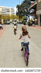 Seville, Spain - Apr 25, 2010: Family Bike Ride. Cycling Through The  Remedios Neighborhood In Seville, Andalusia, Spain