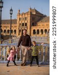 SEVILLE, SPAIN father and kids play outside Plaza Espana  in Sev