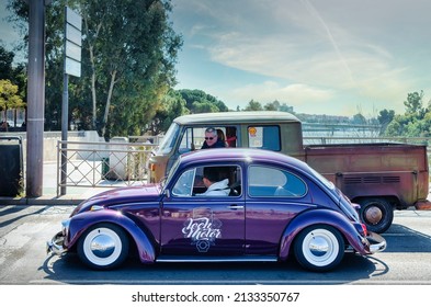 Seville, Spain; March 6, 2022: Two Men Driving Classic Cars At A Red Light.