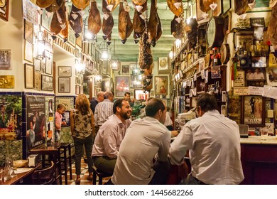 Seville, Spain - September 3rd 2015: Men eating and drinking in a tapas bar in the old city. The area is a popular evening venue.