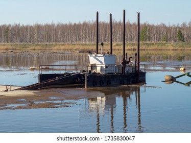 A sewage barge cleans the lake against the background of the forest.