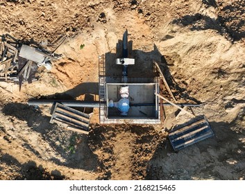 Sewage Construction, Stormwater And Sanitary Sewer. Chamber And Pump Station. Sewerage Manhole And Pipes At Construction Site. Resilient Seated Gate Valves Connect Pipeline Of Water Supply. 