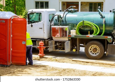 Sewage Truck On Worker Pumping Feces Out Of Rental Toilet For Disposal And Cleaning At The Construction