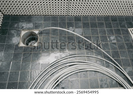 Sewer cleaning. Cleaning the sewer with a cable. Plumber using a drain snake to unclog the shower. Plumbers extracting snake tool.