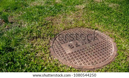 a sewer entry grate in the middle of a lawn
