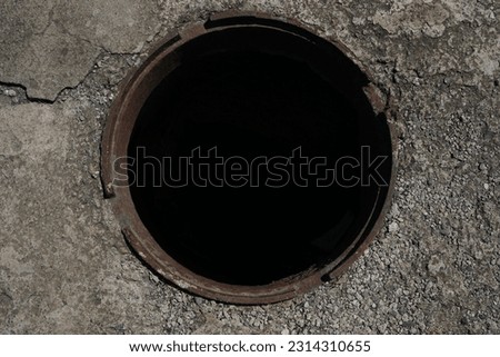 Sewer hatch without lid. isolated on black background. dark hole, pit. top view. concrete floor.