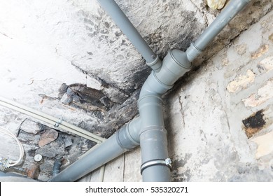 Sewer Pipes In Home Basement. System Of Gray Sanitary Pipes In Old House.