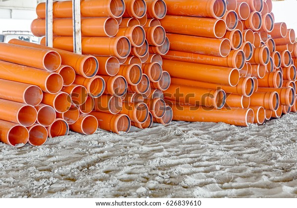 Sewer pipes waiting to be placed into the ditch at\
construction site.