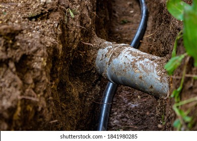 Sewer and water pipe in an excavated trench deep in the ground, close up. Sewerage and water system repair concept.