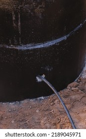 Sewer Well Covered With Bituminous Waterproofing And A Pipe Inside The Trench