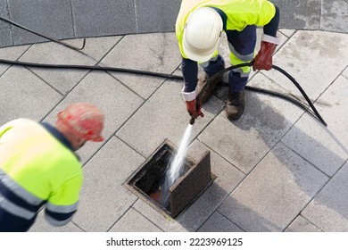 sewer workers working  for cleaning with water pressure on maintenance by the system sewage in city street - Shutterstock ID 2223969125