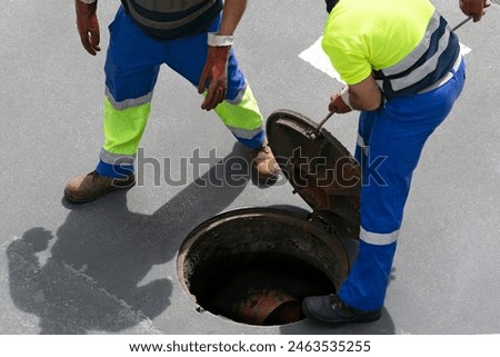 sewerage service worker checking the sewer pipe lines on  city street