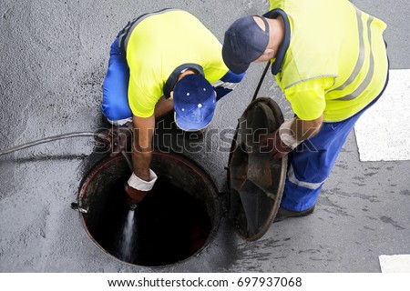sewerage workers  draining the sewer line