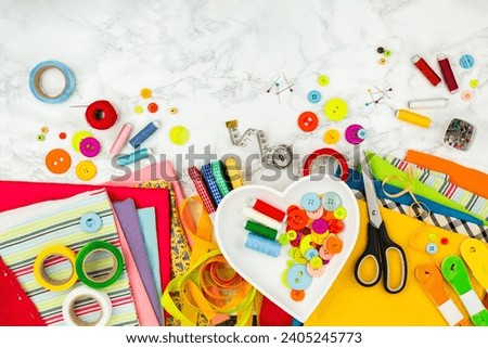 Sewing accessories with bright colors, top view. Colorful fabrics, buttons, strips and other materials for needlework. Tailor's equipments. Sewing and home needlework. Recycling of clothes