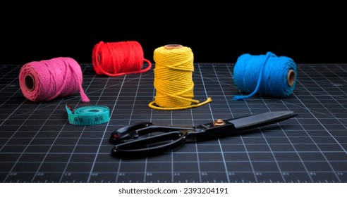 Sewing Accessories isolated on black background. Threads balls, scissors, measuring tape.