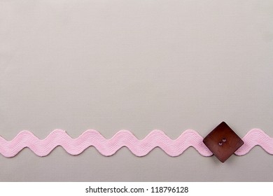 Sewing background with button and rick rack on  material