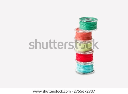 Sewing bobbins with colored threads on a white background.