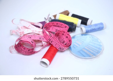 Sewing essentials including threads, measuring tape, and needles on a white background.